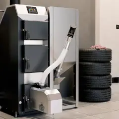 Nowoczesny piec na pellet, obok stos opon. Wygląda na to, że brakuje pelletu do jego działania.