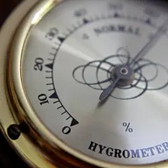 Złoty higrometr pokazuje niską wilgotność w domu, poniżej 10%.