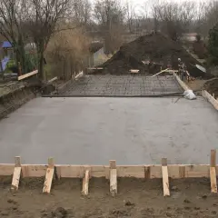 Budowa fundamentów: świeżo wylany strop monolityczny, zbrojenie czeka na beton.