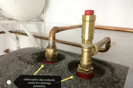 Dwa mosiężne śrubunki z miedzianymi rurkami, jeden z zaworem bezpieczeństwa. Po odkręceniu woda leci, powietrza brak.